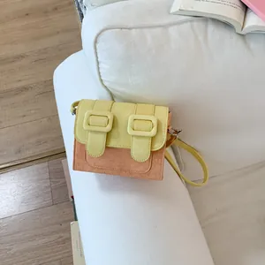Detailed view of a trendy contrast color crossbody square bag on a white sofa