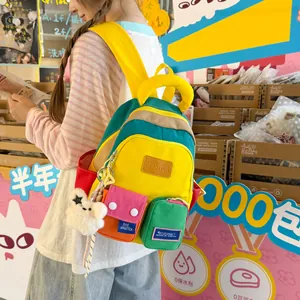 Close-up of a colorful block backpack with multiple utility pockets and a plush bear charm
