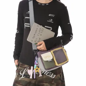 Detail view of a multi-color crossbody bag with a transparent pocket and accessories.