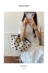Stylish women's cream tote bag featuring large black polka dots and a palm charm