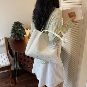 Grand sac cabas blanc à motif étoilé avec poignée tressée porté par un mannequin