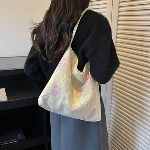 Detailed view of a new Chinese style bucket bag with floral embroidery and braided strap