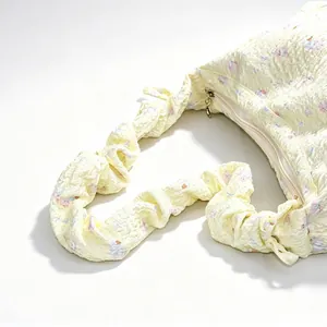 Detailed close-up of yellow floral bubble textured handbag with scrunchie shoulder strap