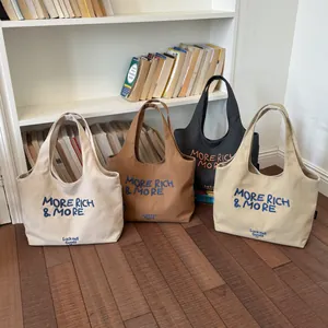 Vista detallada de cuatro elegantes bolsos de lona en varios colores en un ambiente real.