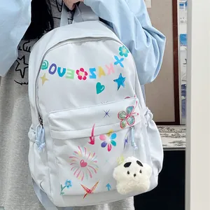 Detail of a light blue fashionable backpack with colorful doodle art and star plush pendant.