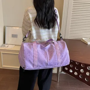 Vista trasera bolso de viaje morado con estrellas y lunas llevado al hombro