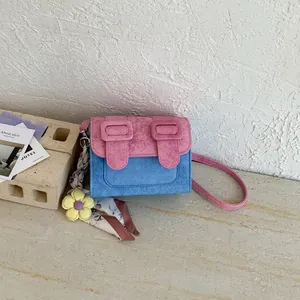 High-quality detail of a trendy pink and blue color-blocked small square crossbody bag