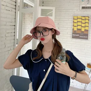 Stylish pink ruffled bucket hat worn by a female model for summer sun protection.