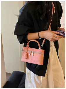 Fashionable pink mini box bag styled with a black jacket and a white skirt outfit.