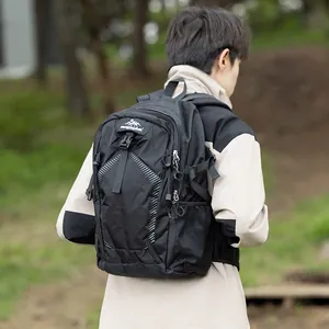 Professional black waterproof outdoor hiking backpack worn by a person in a natural setting