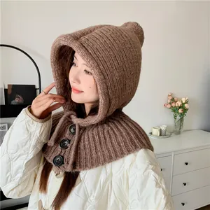 Side view detail of a warm brown knitted balaclava hood scarf with decorative buttons