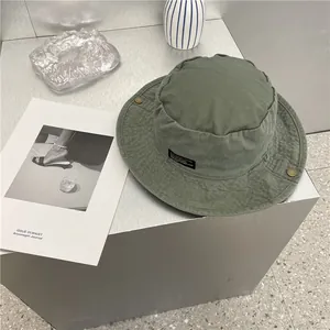 Detailopname van een vintage groene katoenen vissershoed op een grijze sokkel