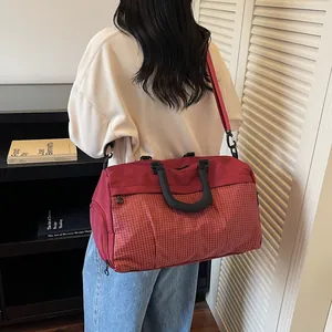 Detail of stylish reddish-pink travel bag with grid pattern for outdoor and commuting