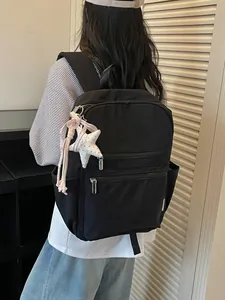 Mochila negra minimalista de estilo coreano para mujer con un encantador accesorio de estrella
