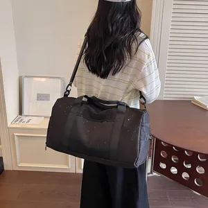 Bolsa de viaje grande negra con sutil patrón de estrellas en el hombro de la modelo