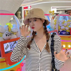 Cute khaki bucket hat with embroidered bunny ears worn by a model in a shopping mall