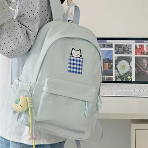 Detail of a light blue Japanese style backpack with a cute cat pocket embroidery.