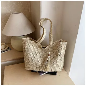 Détail d'un sac cabas en paille tissé à la main avec un gland élégant et design épuré