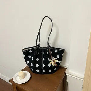 Stylish black polka dot tote bag with a tropical palm tree charm detail
