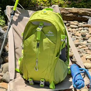 Großer lindgrüner Wanderrucksack in einer malerischen Outdoor-Campingumgebung mit Ausrüstung