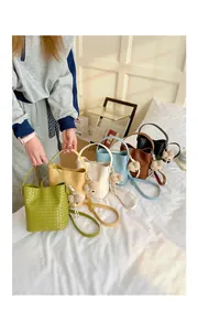 Close-up of retro woven bucket bags in six colors featuring adorable bear keychains.