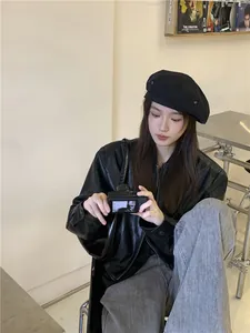 Female model wearing a black vintage denim beret hat in a trendy lifestyle setting