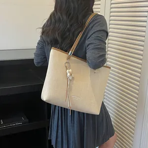 Large capacity beige woven tote bag for women commuting shown on a model's shoulder
