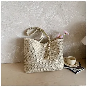 Sac fourre-tout en paille tissé à la main avec gland et fleurs dans un décor de vie