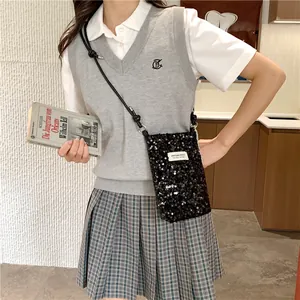 Vista dettagliata di una elegante mini borsa a tracolla nera con paillettes indossata da una modella.