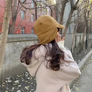 Detailed side view of a stylish warm mustard yellow winter earflap hat with soft texture