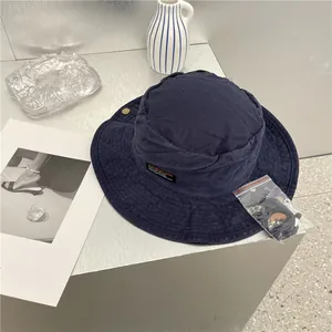 Detail van een marineblauwe retro denim vissershoed met een verstelbare zwarte kinband