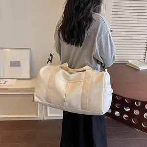 Vista posterior de una modelo con un bolso de viaje crema con estampado de luna.