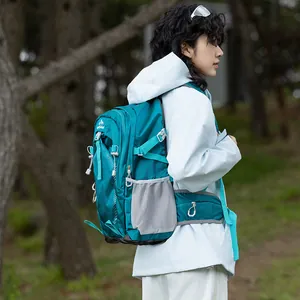 Outdoor lifestyle shot of a woman wearing a teal waterproof hiking backpack in a forest