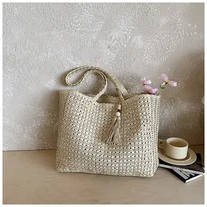 Vue détaillée d'un sac cabas en paille tissé à la main avec breloque à pompon