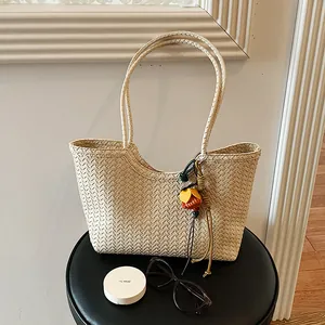 Bolso tote trenzado crema minimalista con un elegante amuleto de flor decorativo