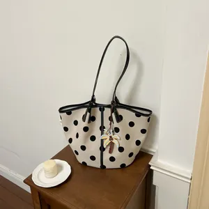 Stylish cream canvas tote bag with large black polka dots and a palm tree charm