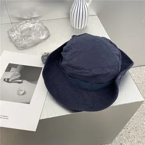 Gedetailleerd overzicht van donkerblauwe denim vissershoed met retro gewassen textuur
