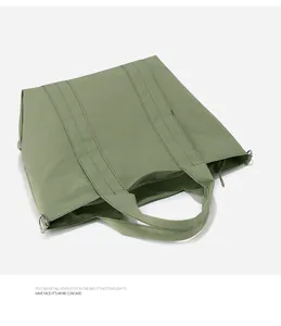 Vista dettagliata della borsa tote verde da ufficio con interno spazioso e manici robusti.