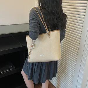 Detailed view of summer woven tote bag with white flower charm and brown straps