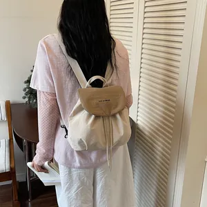 Vue arrière d'une fille portant un élégant sac à dos beige à cordon style coréen