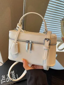 Elegant white leather box bag vanity case featuring a top handle and adjustable shoulder strap