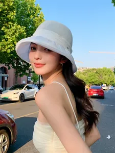 Elegant white breathable sun hat for women shown in a stylish outdoor street setting