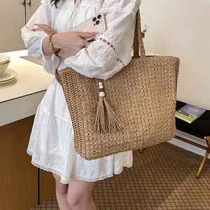 Vue style de vie d'un sac cabas en paille tressée minimaliste avec détail de gland décoratif