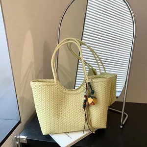 Vista detallada del bolso tote de cuero tejido amarillo pálido con adorno de flor