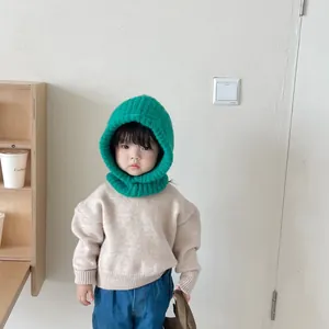 Detail of a child wearing a vibrant green knitted integrated balaclava scarf hat