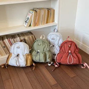Elegantes minimochilas en colores suaves como verde y coral en un entorno acogedor.