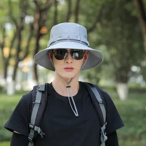 Outdoor portrait of a men's light grey sunshade bucket hat with adjustable chin strap