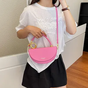Modische rosa halbmondförmige Satteltasche mit goldenem Ringgriff an einem Modell