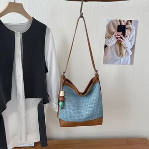 Detail view of a blue woven bucket bag hanging in a minimalist lifestyle setting