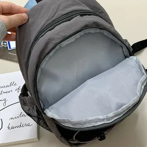 Primer plano del espacioso compartimento interior de esta mochila gris casual retro